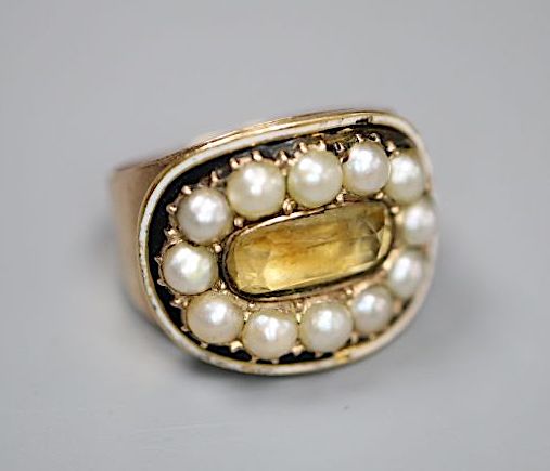 A George III yellow metal, black enamel, split pearl and foil backed citrine set oval mourning ring,